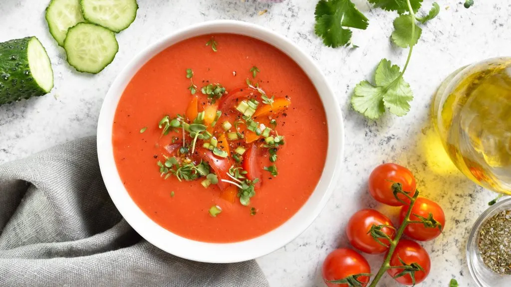 Gazpacho soup in bowl over light stone background. Healthy food concept. Top view, flat lay