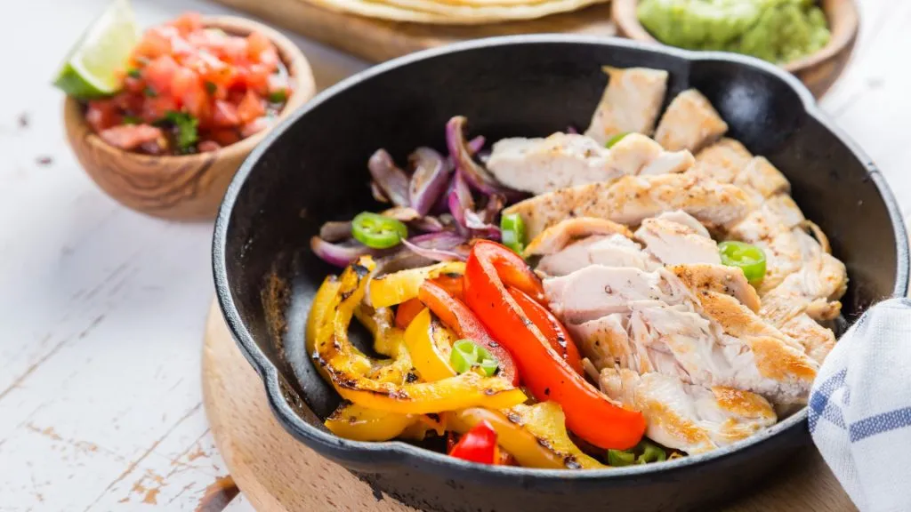 Grilled chicken fillet with bell pepper, onion and guacamole