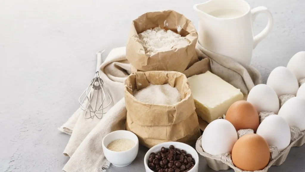 Various baking ingredients for sweet pastry. Dough recipe. Milk, flour, eggs, sugar and butter. Common allergies