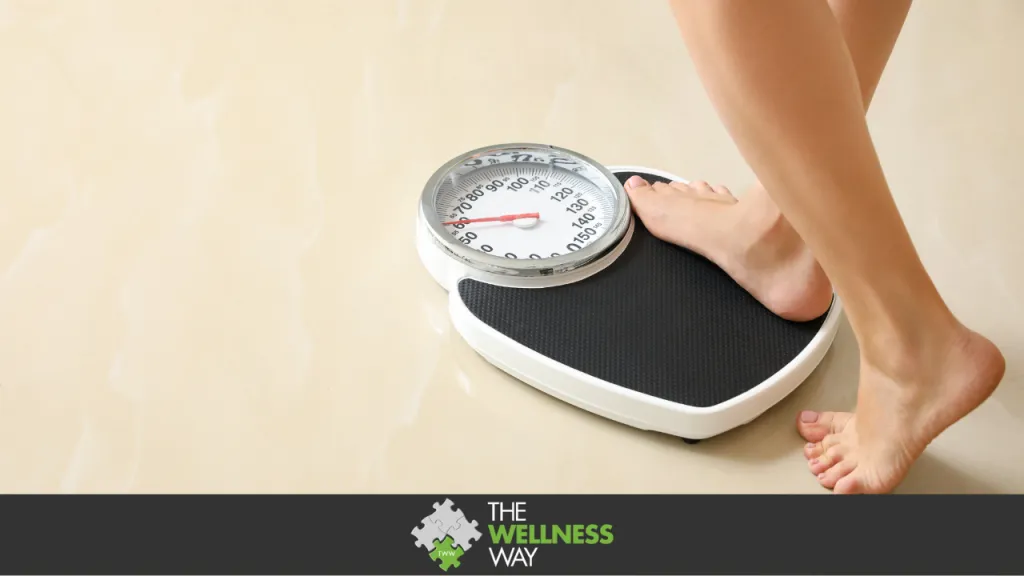 Woman stepping on floor scales indoors, weight loss