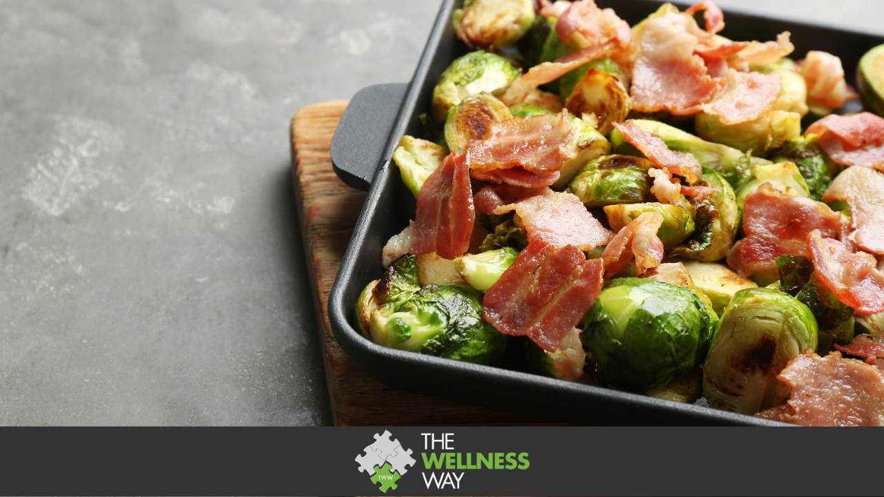 Closeup of hot cooked grilled brussels sprouts served with roasted bacon on grey wooden table. Delicious appetizing salad for diet. Closeup on delicious baked brussels sprouts and bacon on grey table. Appetizing christmas breakfast, healthy diet food, natural low carb meal serving.