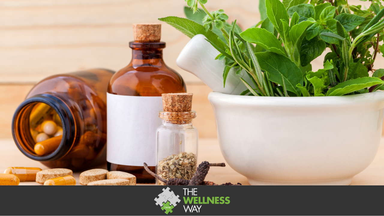 pills, liquid herbs in bottle and green plant on a wooden table looking background