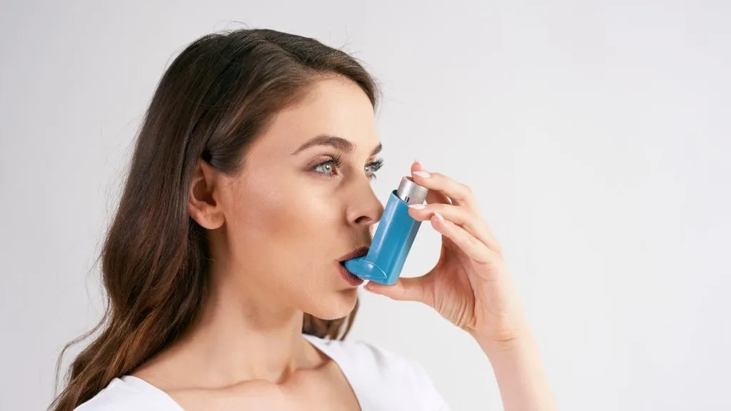 Asthmatic woman using an asthma inhaler during asthma attacks