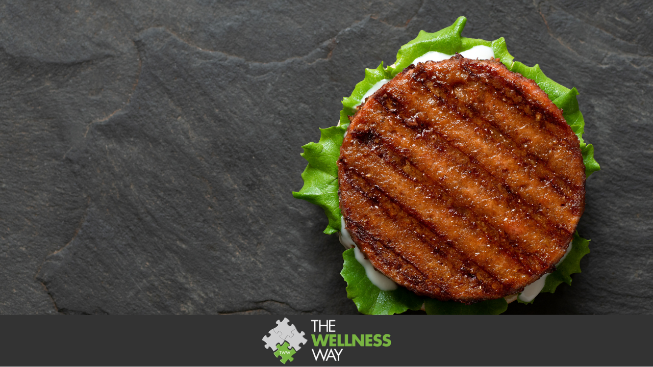Freshly grilling plant-based burger with tomato sauce isolated on black background top view. Juicy grilled burger with lettuce and tomato on griddle with protein copy space. Freshly grilled burger with lettuce plant patty and tomato sauce in black slate griddle isolated on white background, alternative health food, top view copy space.