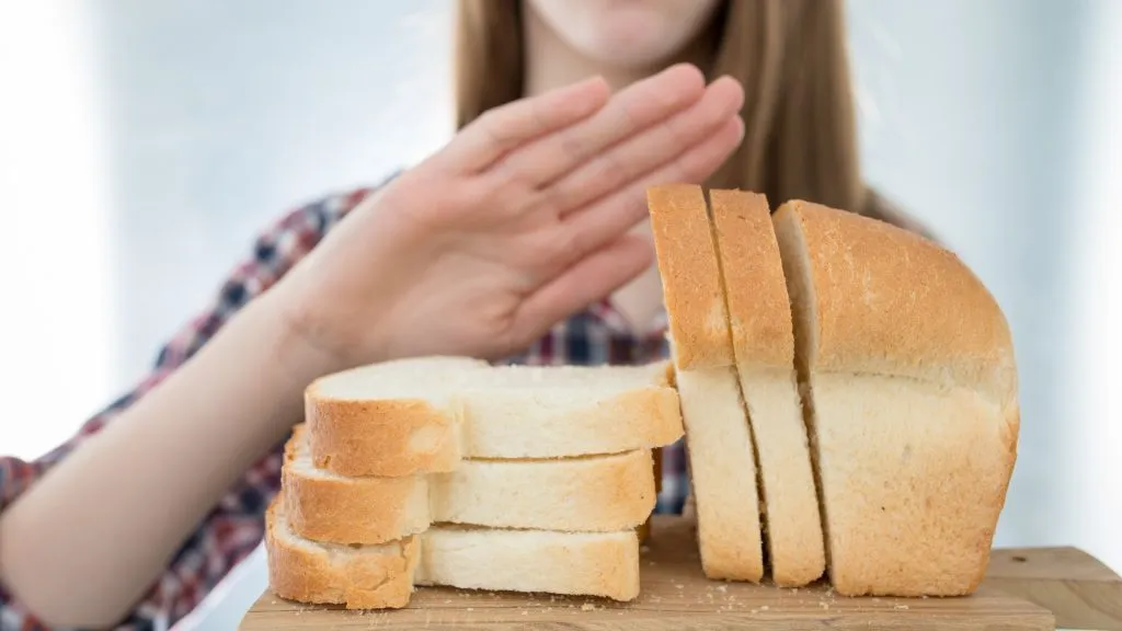 Gluten intolerance concept. Young girl refuses to eat white bread