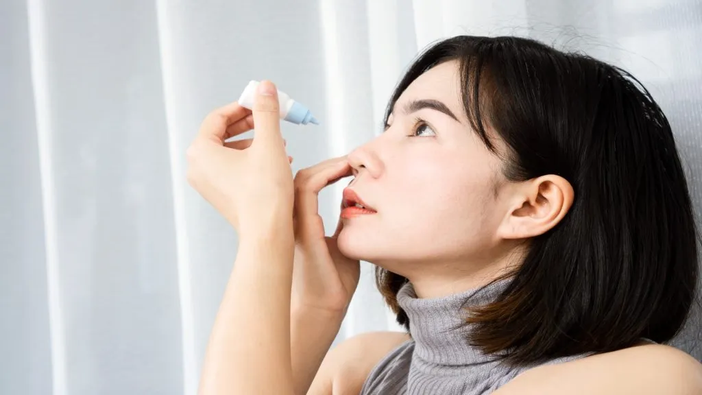 Asian woman applying eye drops to refresh from dry, tired eyes