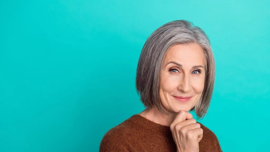Portrait of a beautiful senior woman on a turquoise background